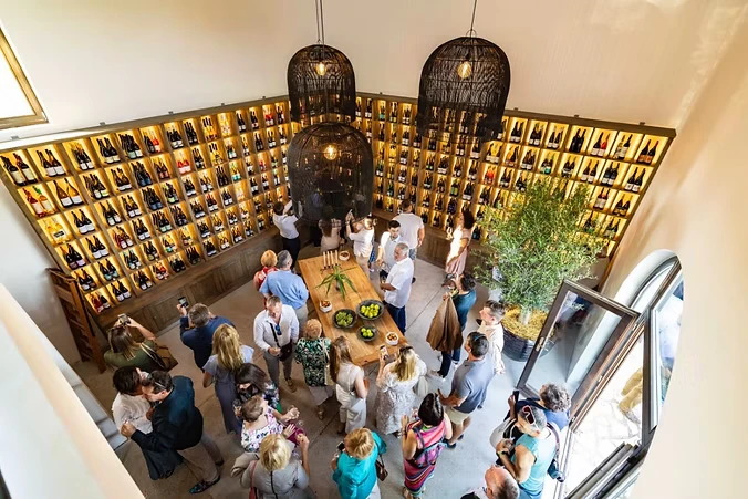 Vendégek a Balaton Wines Visitor Center borokkal körülvett kóstolóterében